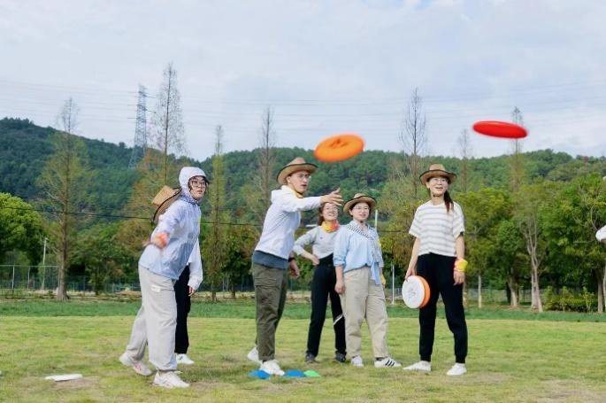 团队在草坪上玩飞盘嘉年华团建游戏
