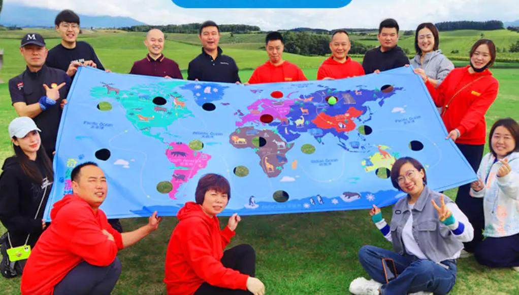 团队成员手拉世界球地图布协作绕球